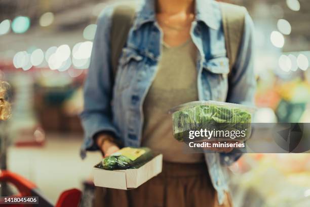 anonymous woman holding boxes of green vegetables at the supermarket - spinach stock pictures, royalty-free photos & images
