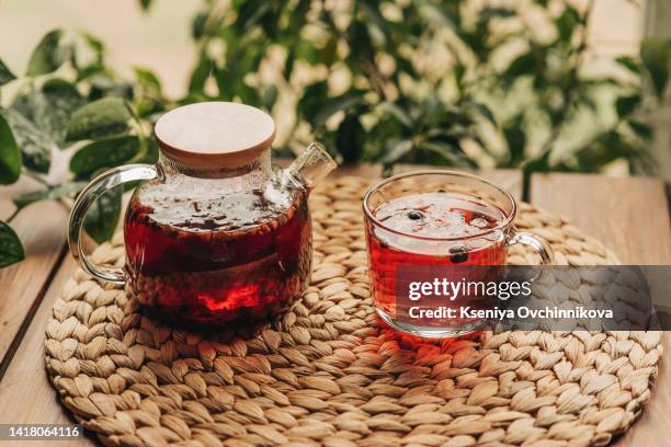 modern teapot with red berry tea. hot raspberry drink. cozy autumn concept - tea hot drink - fotografias e filmes do acervo