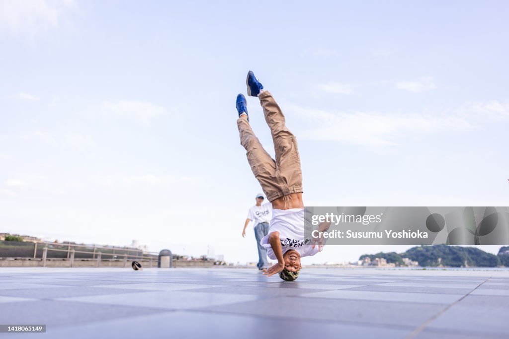 Friends break dancing in a park by the sea.