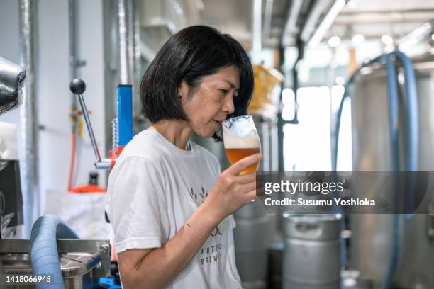 female owner and young male brewer brewing beer in a microbrewery. - taste test stock pictures, royalty-free photos & images