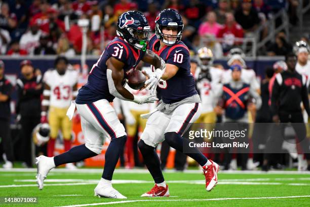 Davis Mills hands the ball off to Dameon Pierce of the Houston Texans in the first quarter during a preseason game against the San Francisco 49ers at...