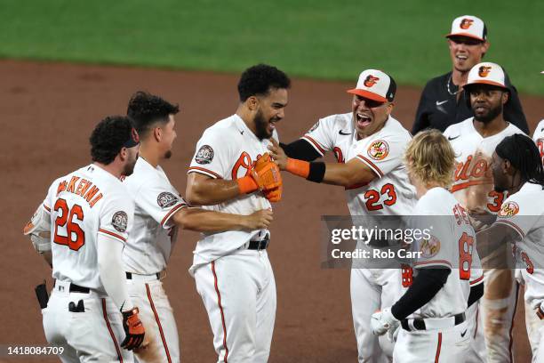 Anthony Santander of the Baltimore Orioles is mobbed by teammates after hitting a walk off single against the Chicago White Sox in the 10th inning...