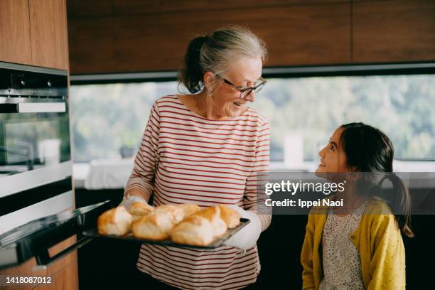 grandmother and granddaughter baking scones in kitchen - granddaughter stock pictures, royalty-free photos & images