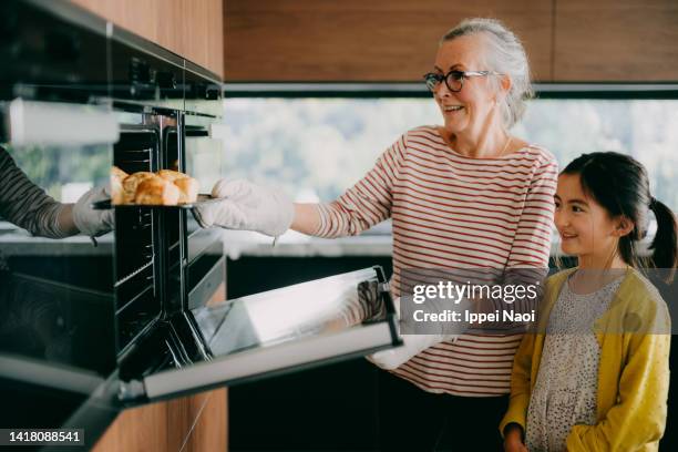 grandmother and granddaughter baking scones in kitchen - family baking bread stock pictures, royalty-free photos & images