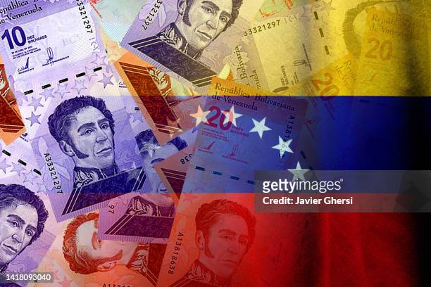 bolívares cash bills and venezuela flag - bolívar venezolano divisa fotografías e imágenes de stock