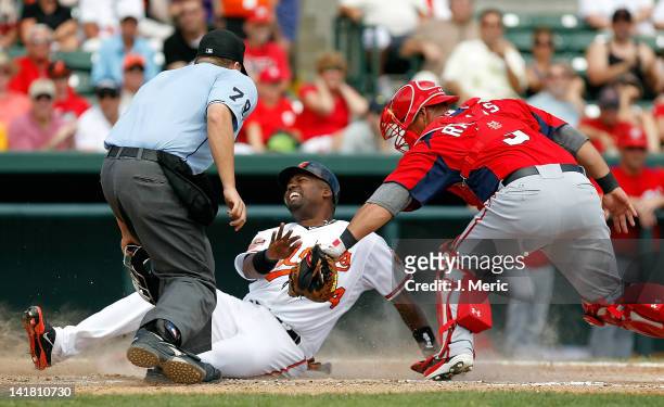 Designated hitter Wilson Betemit of the Baltimore Orioles is tagged out at home by catcher Wilson Ramos of the Washington Nationals during a...