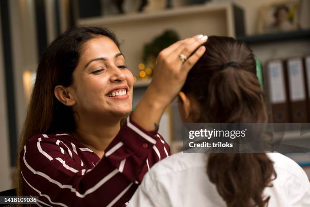 mother getting her daughter ready in school uniform at home - mom head in hands stock pictures, royalty-free photos & images