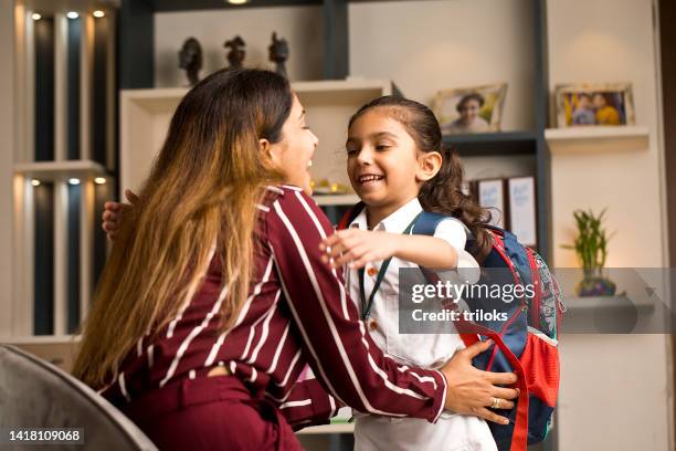 girl embracing mother before going to school - parent daughter school uniform stock pictures, royalty-free photos & images