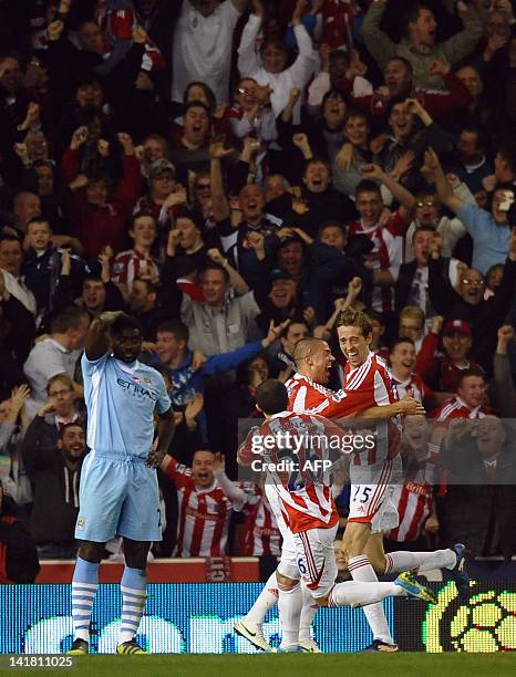 Stoke City's English striker Peter Crouch celebrates with team-mates after scoring the opening goal of the English Premier League football match...