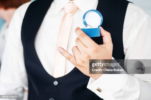 groom holding jewelry box with bride's ring. - alliance mariage stock-fotos und bilder
