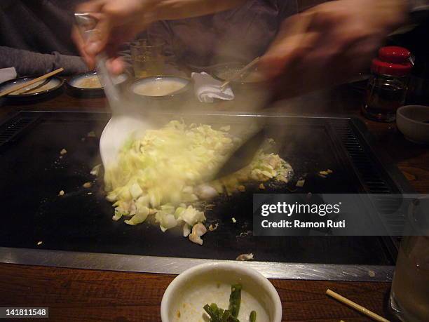 cooking okonomiyaki in tokyo - okonomiyaki stock pictures, royalty-free photos & images