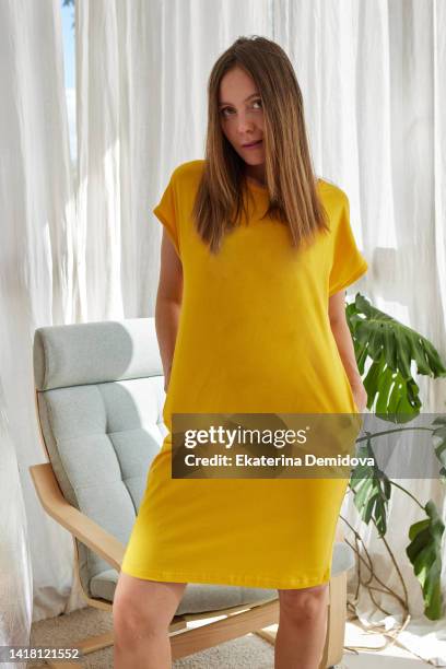 woman in yellow dress in light room - long bright yellow dress stock pictures, royalty-free photos & images