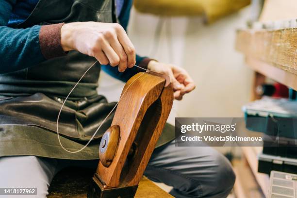 young craftsperson making leather watch strap. - leather strap stock pictures, royalty-free photos & images