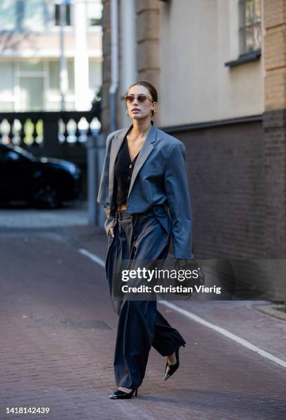 Chelsey Weimar wears Shoes / Prada, Grey pants with wide legs, Black gilet with buttons / Shona Joy, Grey cropped blazer / cut vintage, Sunglasses /...