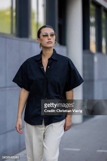 Chelsey Weimar wears Shoes / Prada, Pants / Agreeg, Black blouse / Massimo Dutti, Sunglasses / Ray Ba during a street style shoot on August 25, 2022...