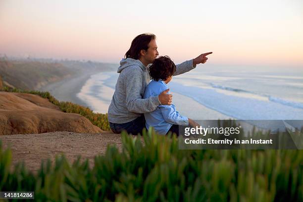 father and son looking at ocean - conveyor belt point of view stockfoto's en -beelden
