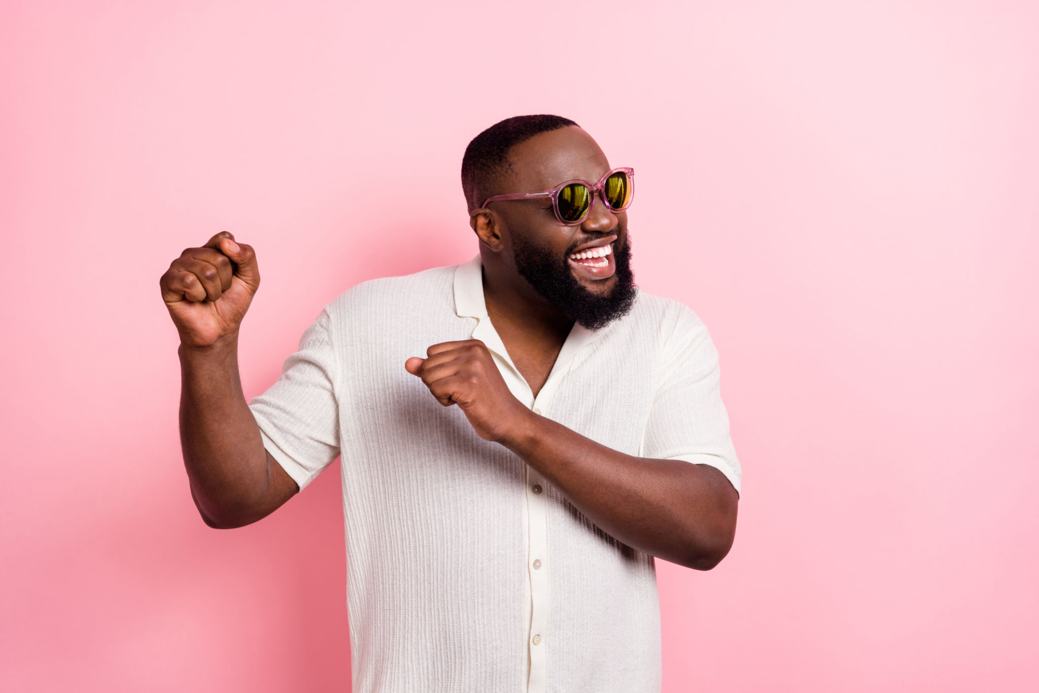 Photo of charming cool young man wear white shirt dark eyewear dancing isolated pink color background Photo of charming cool young man wear white shirt dark eyewear dancing isolated pink color background