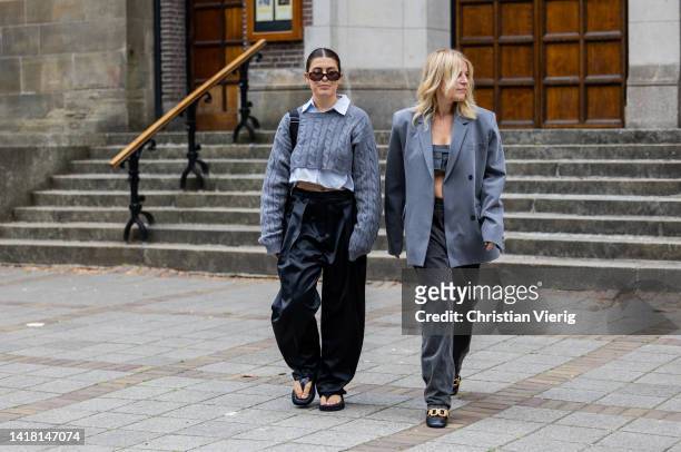 Eva Lagos Meritzos wearing grey cropped Miu Miu knit, white bluse, black pants, sandals, bag & Heleen Hulsmann wearing grey blazer, cropped top,...