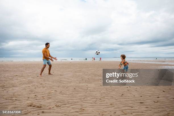 playing catch on the beach - playing catch stock pictures, royalty-free photos & images