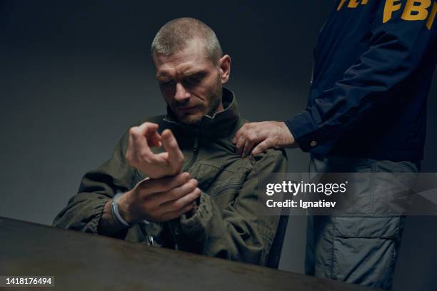 a suspect after interrogation - russian gangster stock pictures, royalty-free photos & images