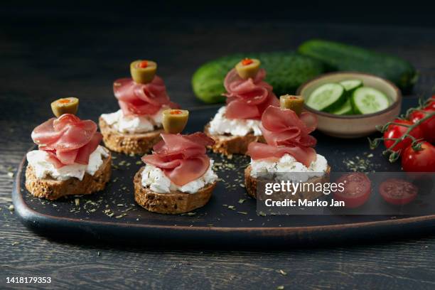 sandwiches with cheese and smoked ham with olives, cherry tomatoes and cucumber - gala table stock pictures, royalty-free photos & images