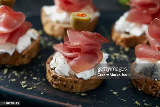 kleine sandwiches mit prosciutto, käse und oliven - rustic cocktails stock-fotos und bilder