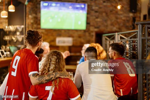 vista posteriore dei tifosi entusiasti che si divertono in un bar mentre tifano per la loro squadra - guardare con attenzione foto e immagini stock