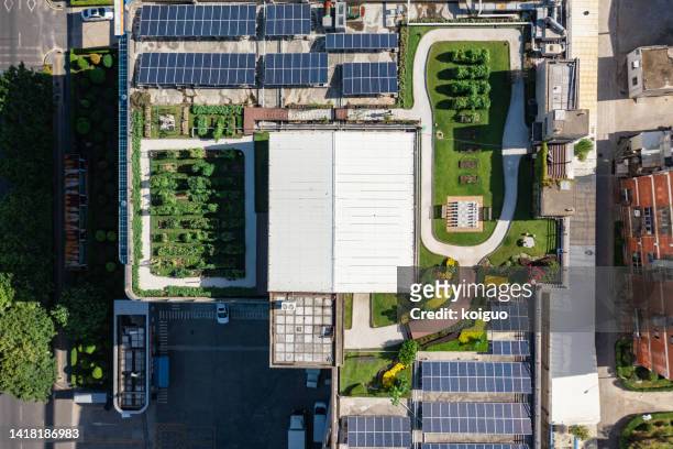 aerial view of roof garden and solar panels in industrial area - green roof stock pictures, royalty-free photos & images
