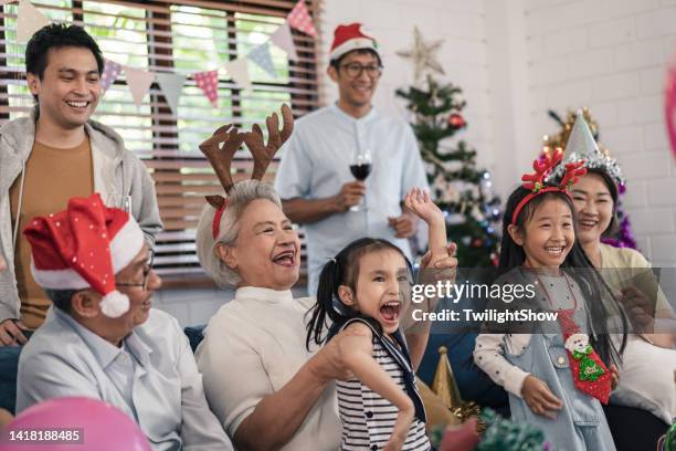 senioren- und enkelgruppe der familie, die spaß hat, weihnachten und neujahrsfeier zu hause zu feiern - 25 30 years old asian stock-fotos und bilder