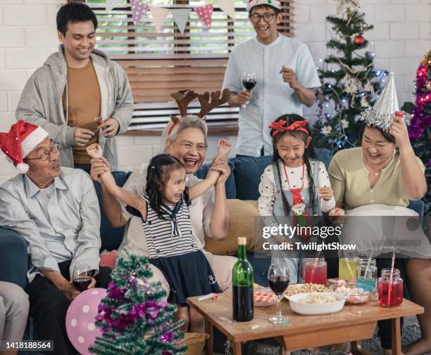 senioren- und enkelgruppe der familie, die spaß hat, weihnachten und neujahrsfeier zu hause zu feiern - 25 30 years old asian stock-fotos und bilder