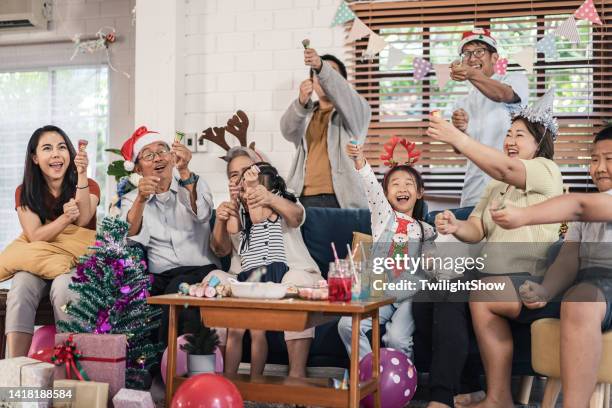 senioren- und enkelgruppe der familie, die spaß hat, weihnachten und neujahrsfeier zu hause zu feiern - 25 30 years old asian stock-fotos und bilder