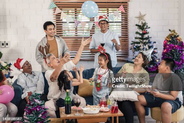 senioren- und enkelgruppe der familie, die spaß hat, weihnachten und neujahrsfeier zu hause zu feiern - 25 30 years old asian stock-fotos und bilder