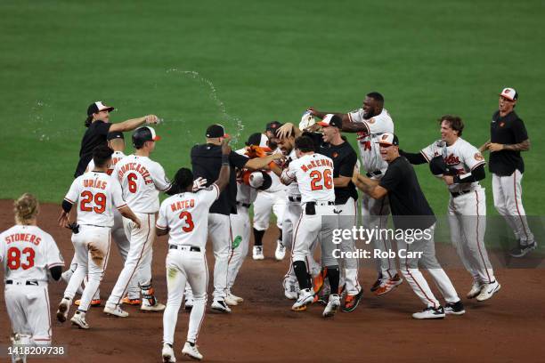 Anthony Santander of the Baltimore Orioles is mobbed by teammates after hitting a walk off single against the Chicago White Sox in the 10th inning...