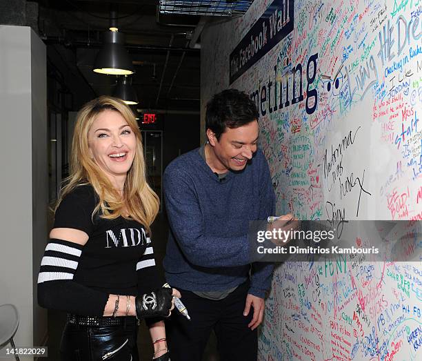 Jimmy Fallon and Madonna sign the Facebook wall before their livestream interview at the Facebook offices on March 24, 2012 in New York City.