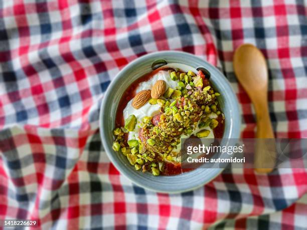 assorted nuts with plain yoghurt and strawberry syrup - pistachio stock pictures, royalty-free photos & images