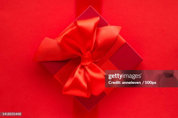 directly above shot of gift box on red background - style studio day 1 stockfoto's en -beelden