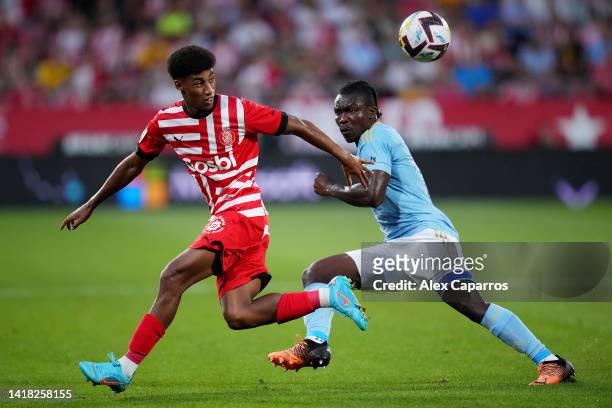 Oscar Urena of Girona FC battles for possession with Joseph Aidoo of RC Celta during the LaLiga Santander match between Girona FC and RC Celta at...