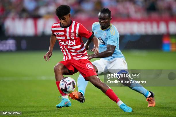 Oscar Urena of Girona FC is put under pressure by Joseph Aidoo of RC Celta during the LaLiga Santander match between Girona FC and RC Celta at...