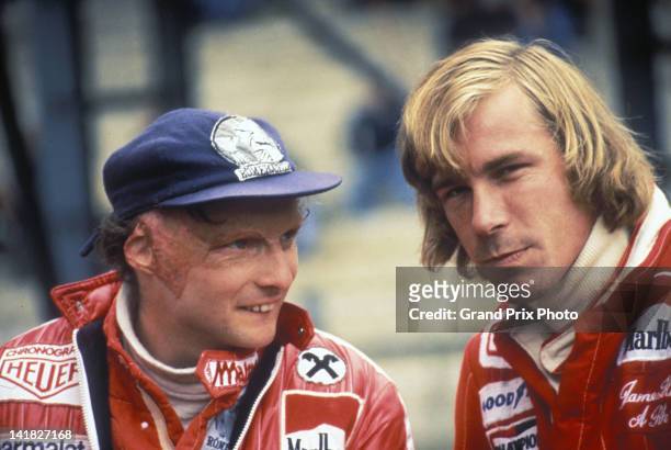 Niki Lauda of Austria, driver of the Ferrari SpA Ferrari 312T2 Ferrari flat-12 talks to rival James Hunt, driver of the MarlboroTeam McLaren M26 Ford...