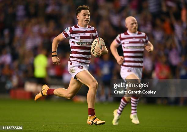 Jai Field of Wigan runs in his team's second try during the Betfred Super League match between Wigan Warriors and St Helens at DW Stadium on August...