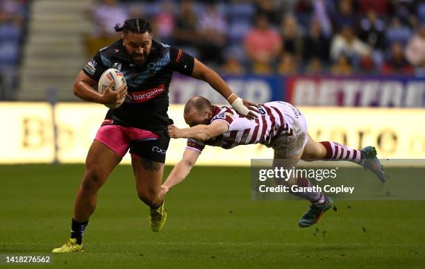 Konrad Hurrell of St Helens is tackled by Liam Marshall of Wigan during the Betfred Super League match between Wigan Warriors and St Helens at DW...