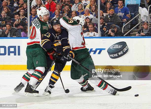 Ville Leino of the Buffalo Sabres gets squeezed by Devin Setoguchi and Nate Prosser of the Minnesota Wild at First Niagara Center on March 24, 2012...