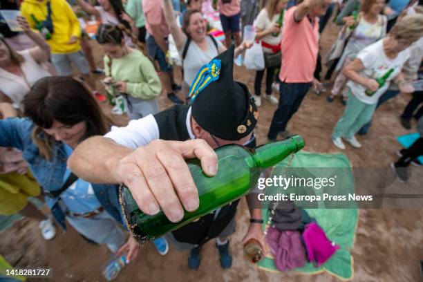 Woman pours cider on the Poniente beach on August 26 in Gijon, Asturias, Spain. The Gijon Natural Cider Festival once again breaks the world record...