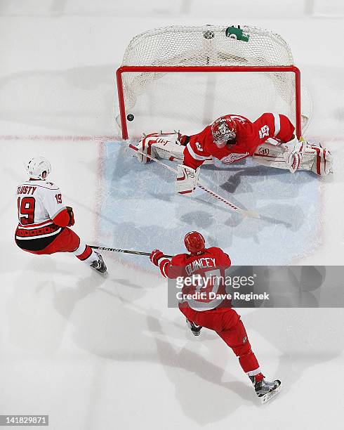 Jiri Tlusty of the Carolina Hurricanes scores a goal on Ty Conklin of the Detroit Red Wings while Kyle Quincey defends during an NHL game at Joe...