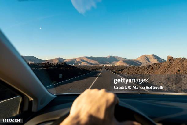 personal perspective of person driving car in lanzarote, spain - punto di vista del guidatore foto e immagini stock