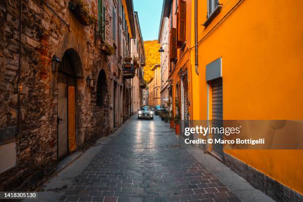 car driving in the old town of como, italy - vicolo foto e immagini stock