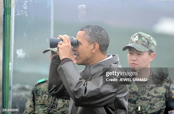 President Barack Obama looks through binoculars towards North Korea from Observation Post Ouellette during a visit to the Joint Security Area of the...