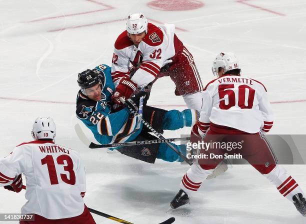 Dan Boyle of the San Jose Sharks takes a hit from Michal Rozsival of the Phoenix Coyotes, as teammates Ray Whitney, and Antoine Vermette look on at...