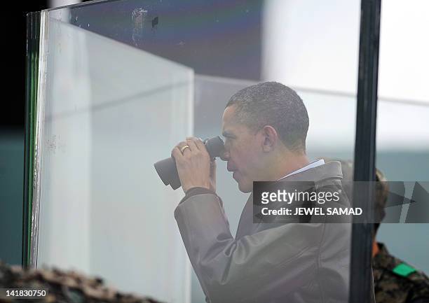 President Barack Obama looks through binoculars towards North Korea from Observation Post Ouellette during a visit to the Joint Security Area of the...