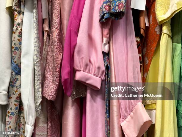 clothing rack of vintage clothing at antique flea market - antique shop stockfoto's en -beelden